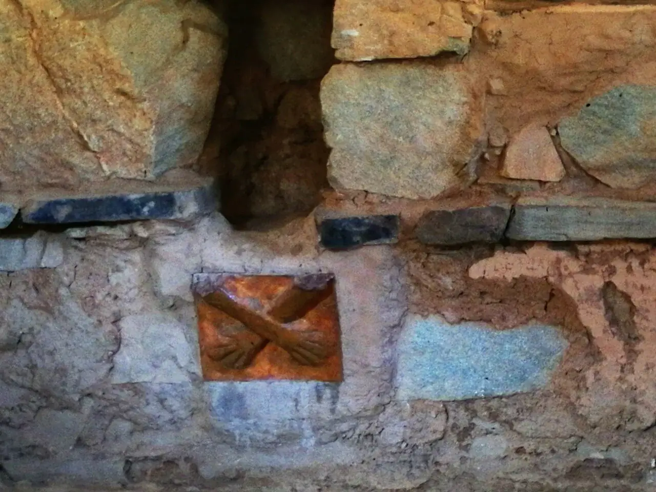 Relieve de barro con dos brazos y manos cruzadas del templo de Kotosh en Perú