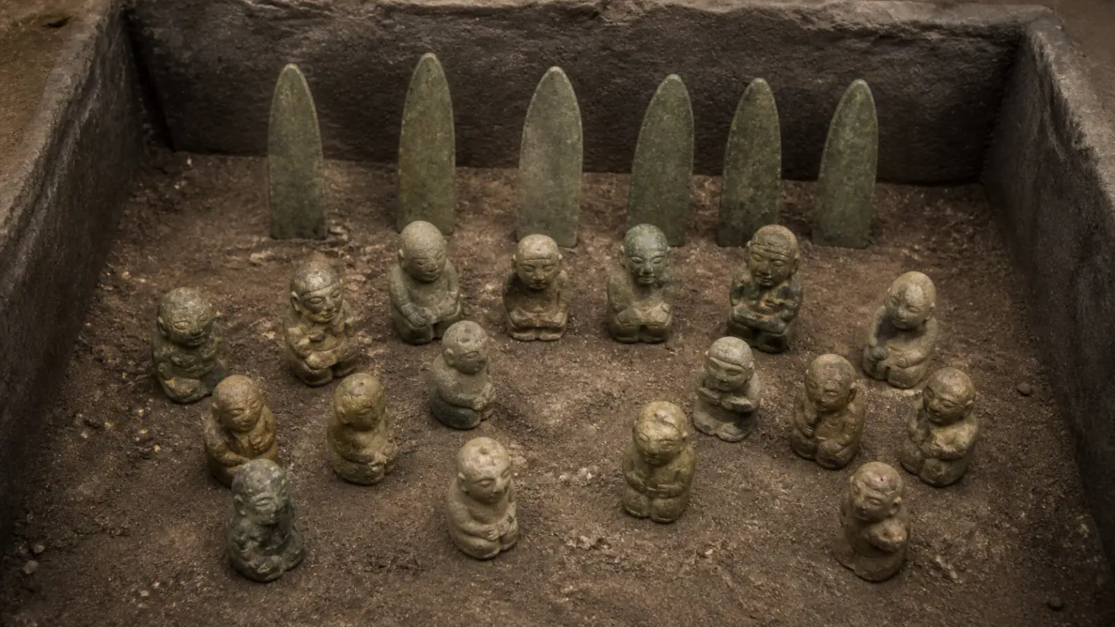 Recreación histórica específica de Dieciséis figuras ante seis hachas como si una reunión quedara suspendida, Complejo A de La Venta, Tabasco, México, c. 800–600 a. C.