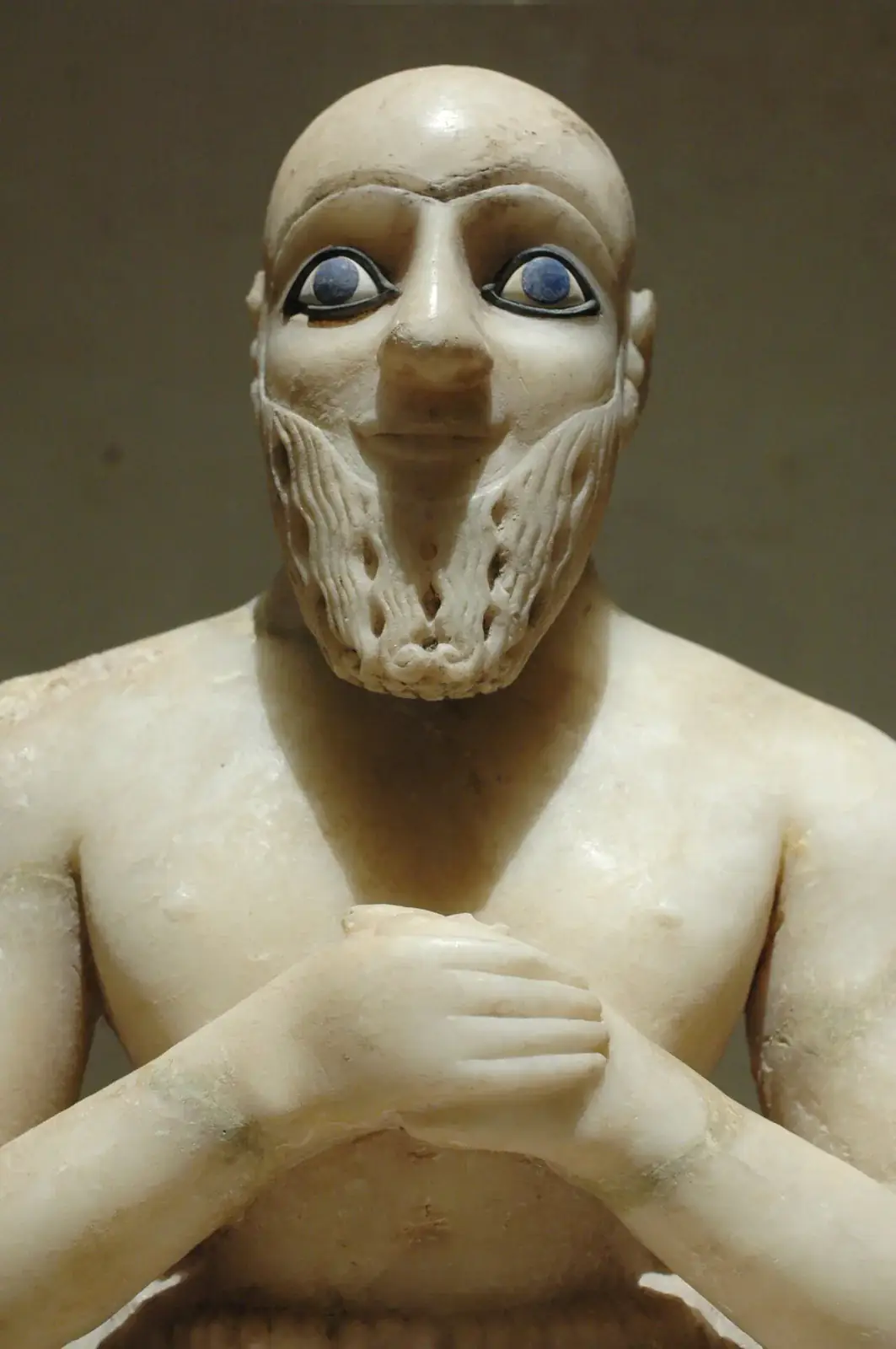 Detalle de cabeza, torso y manos de la estatua original de Ebih-Il; la fotografía no muestra toda la figura sentada.