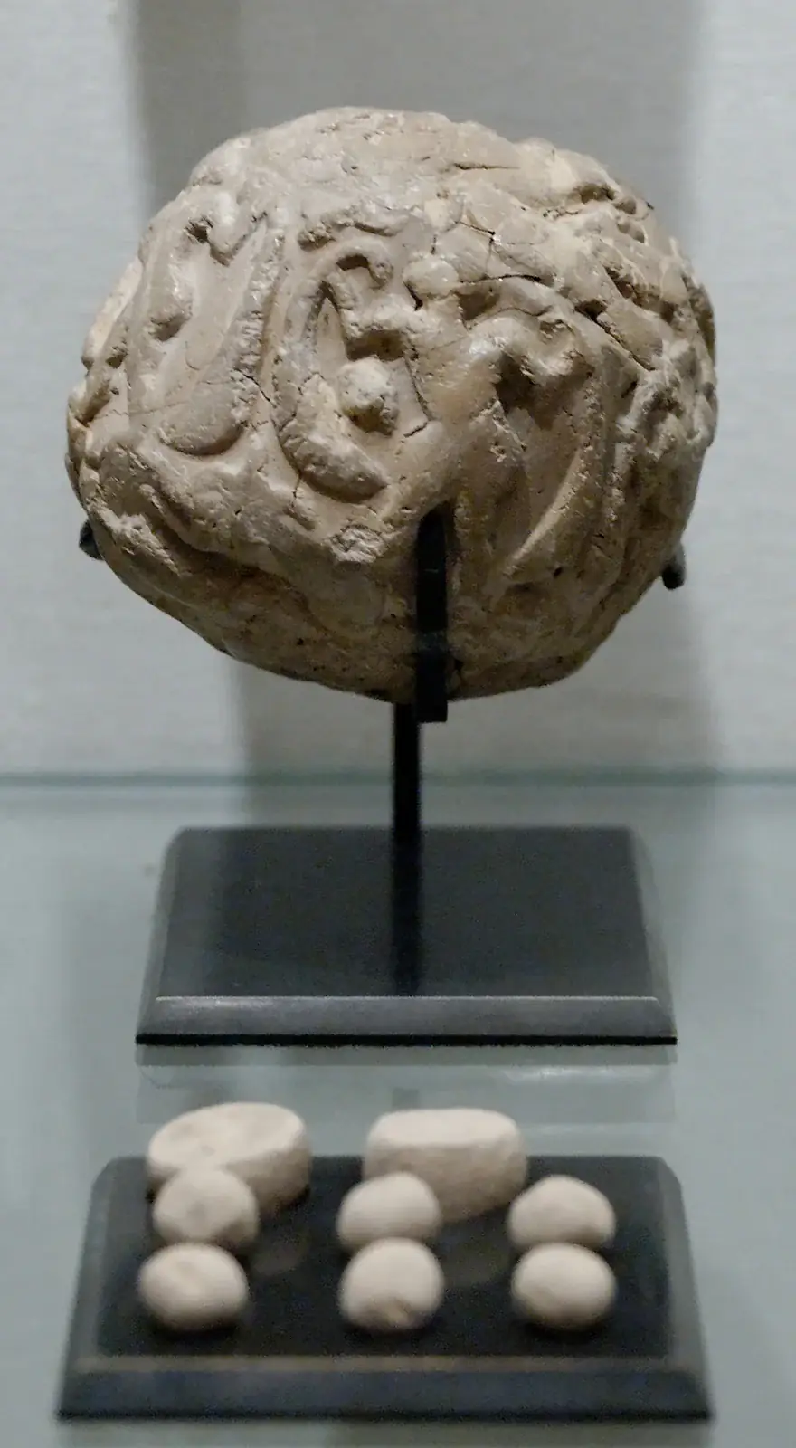 Bulla de arcilla de Susa y sus fichas contables expuestas por separado, Louvre SB 1932; fotografía del original.