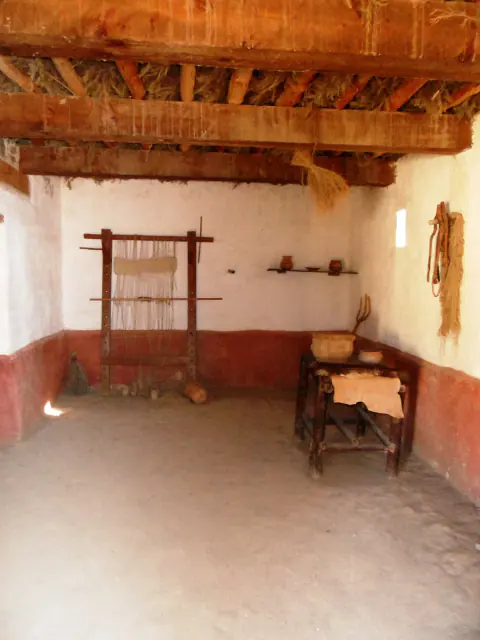 Divisão principal da casa ibérica reconstruída de La Bastida de les Alcusses, com mesa e tear