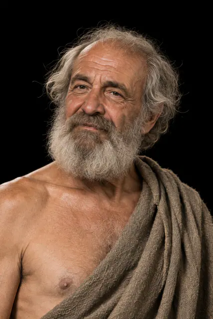 Retrato recriado de Diógenes de Sinope, idoso com barba grisalha e manto de lã, sobre fundo preto; aspeto hipotético.