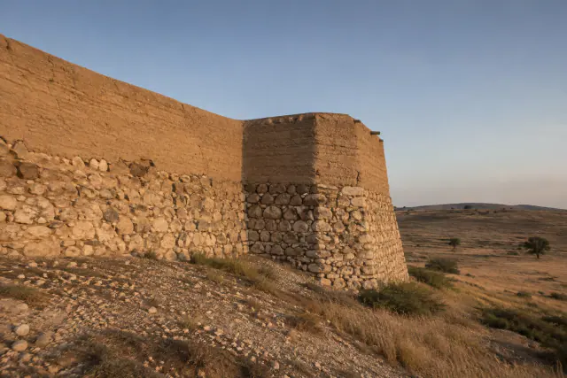 Hipótese visual de um troço da muralha ibérica de Cástulo antes da reforma republicana: alvenaria e adobe na encosta; geometria e alçado não exatos.